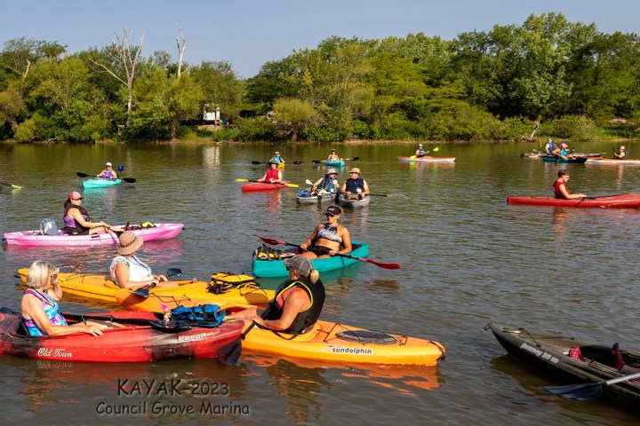 a group of people riding on the back of a boat in the water