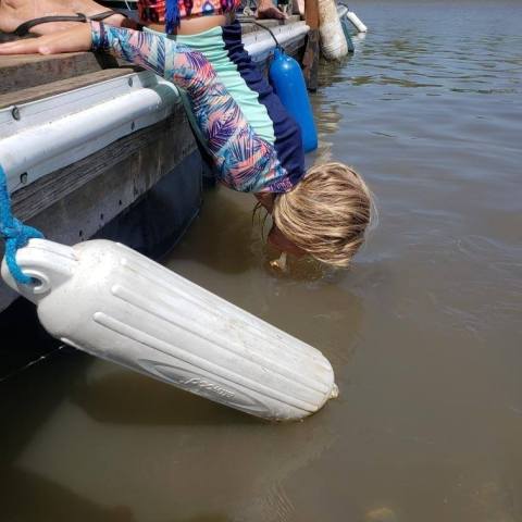 a woman sitting next to a body of water